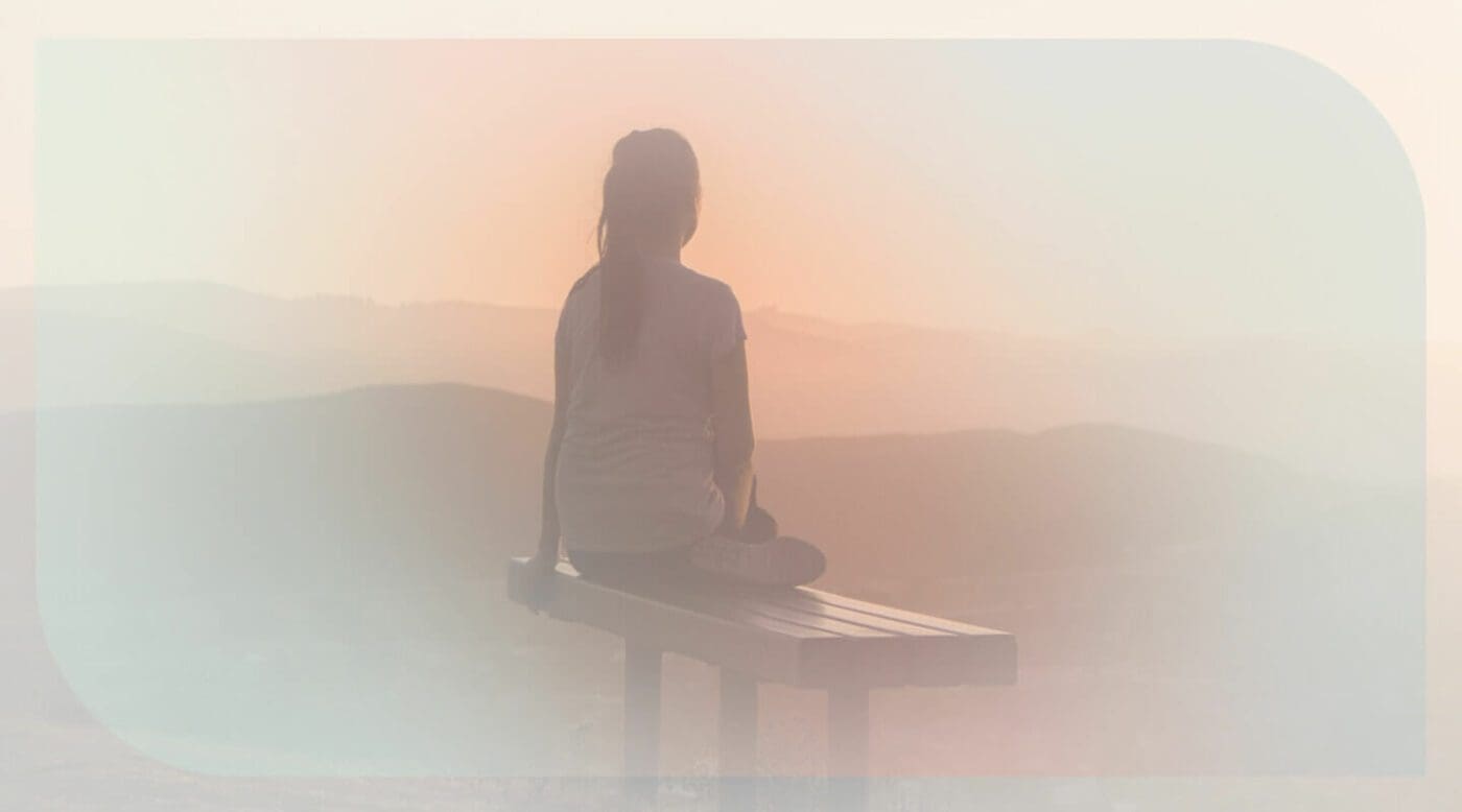Grief And The Power Of Connection - Woman sitting lonely in a bench, watching the sunset