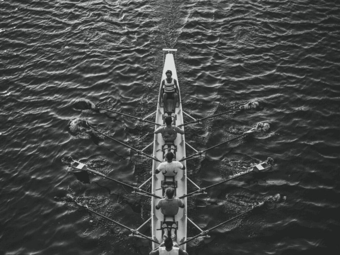4 steps that lead to relational leadership - a team rowing in a boat, with the leader sitting in the front.