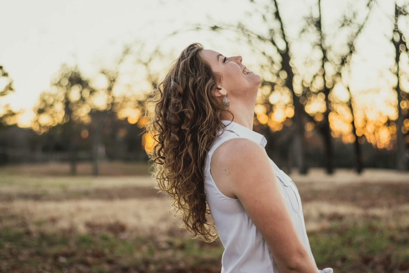 What is Personal Empowerment? 3 Ways to Empower Yourself - A woman in a field, looking up to the sky.