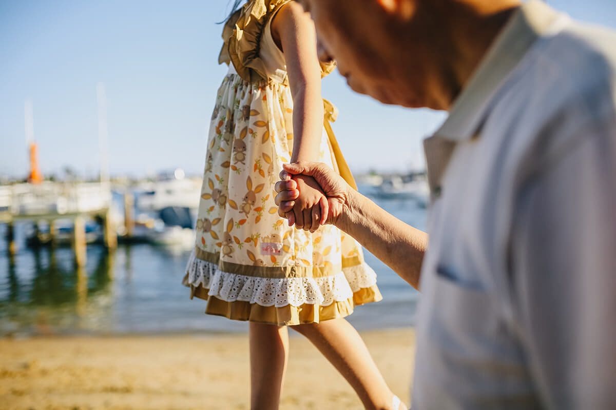 Generational trauma, explained in a nutshell, is that trauma that has been passed down from one generation to the next. Grandfather holding his granddaughter's hand.