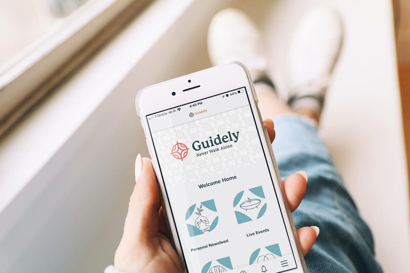 Person holding a phone, navigating the guidely community app. Find self-help and individual counseling in the guidely community app.