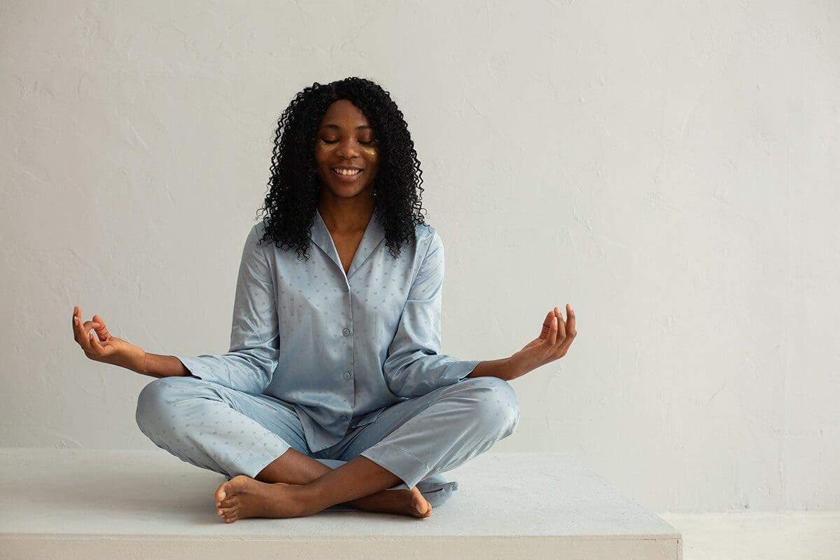 Woman practicing yoga before bed time to fall asleep faster.