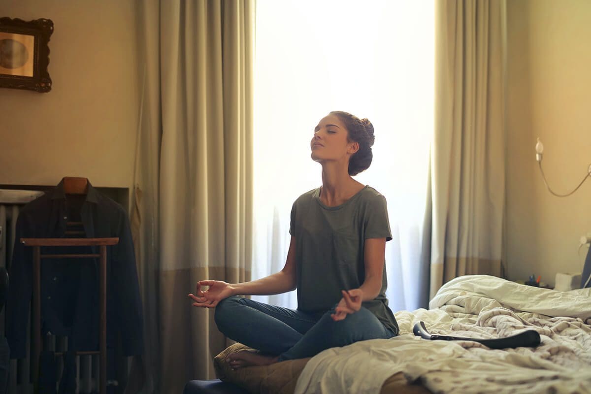 Women meditating in her room, accessing her inner sanctuary through meditation.