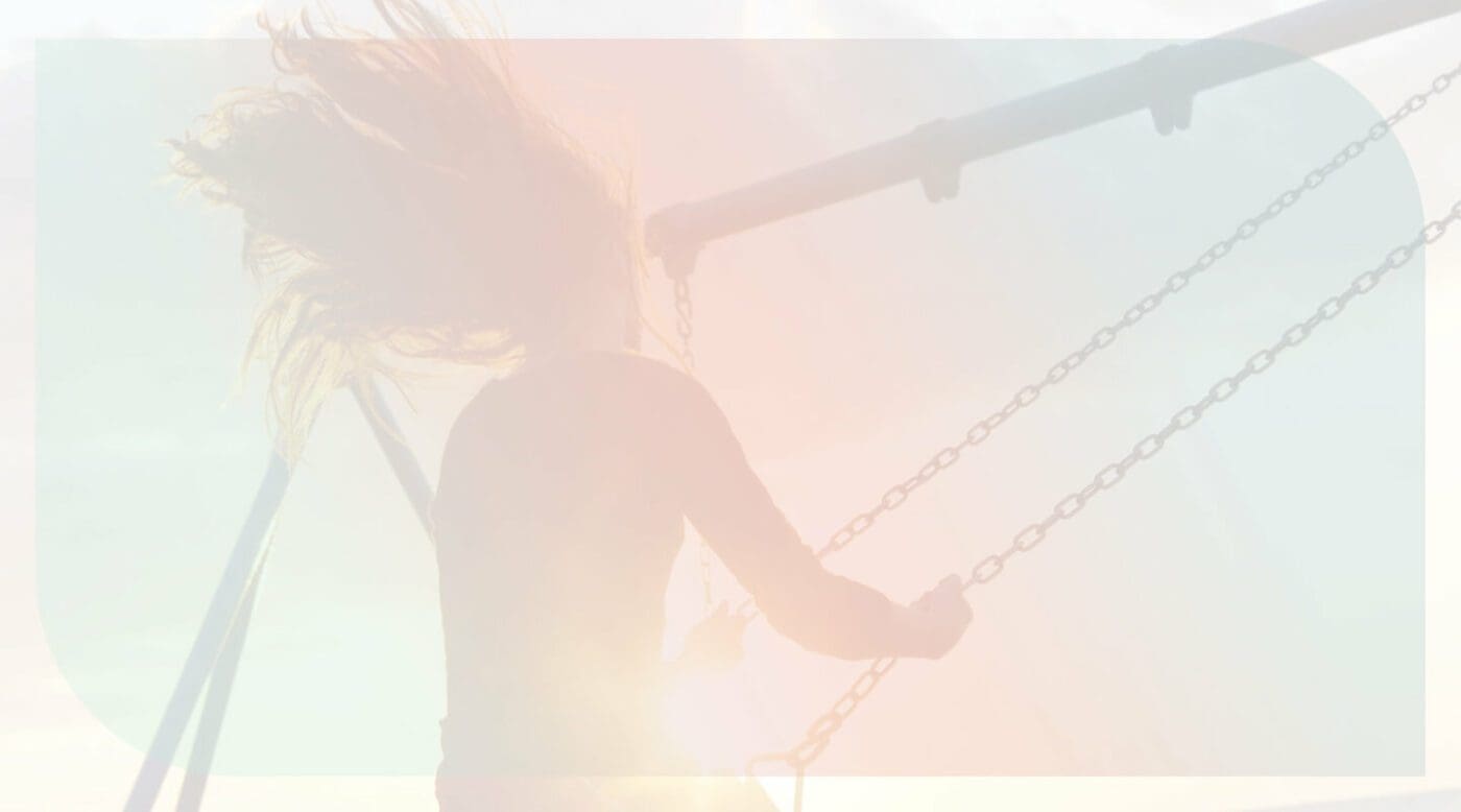 10 Amazing Ways to Reach Happiness in Life and Work. Image shows a woman on a swing, with a sunset behind.
