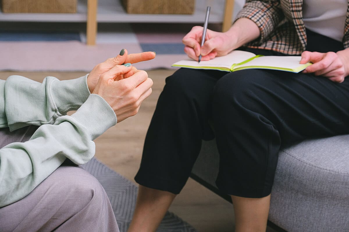 Revolutionize Your Coaching Practice with These 10 Strategies - Anonymous female therapist and client sitting in armchairs during session in modern office.
